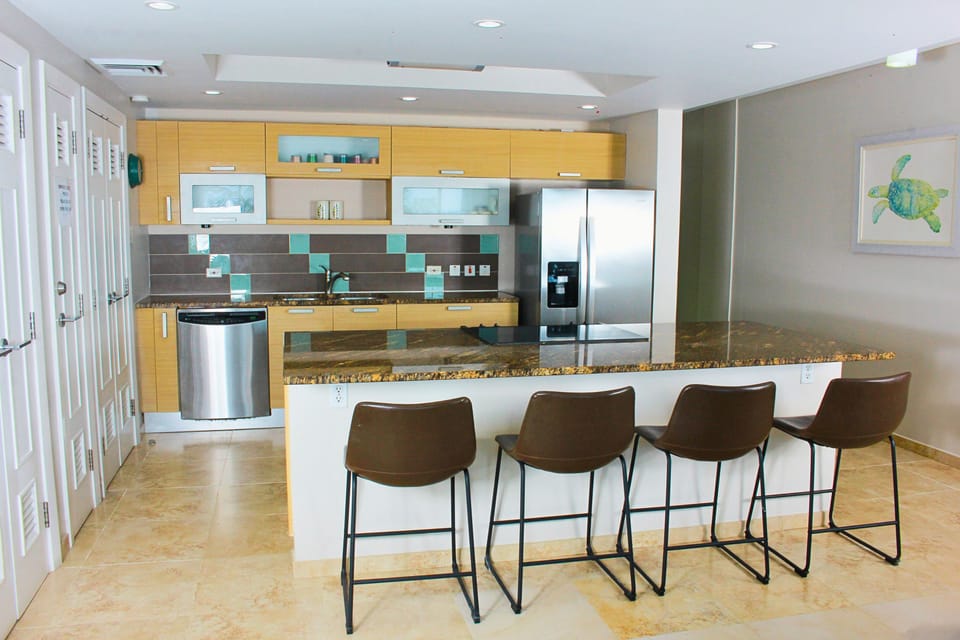 Air-conditioned kitchen with a large island with bar seating and appliances.