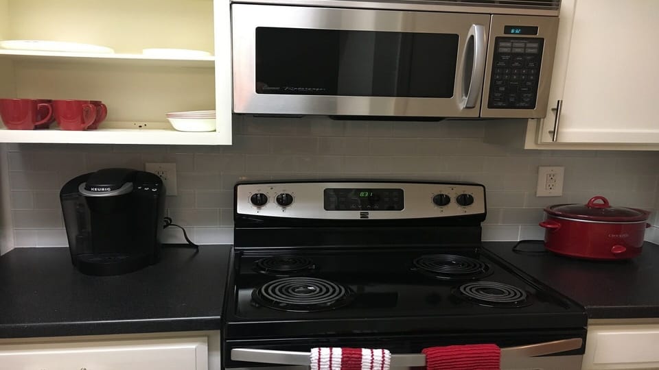 Fully equipped kitchen with appliances, coffee maker and crockpot.