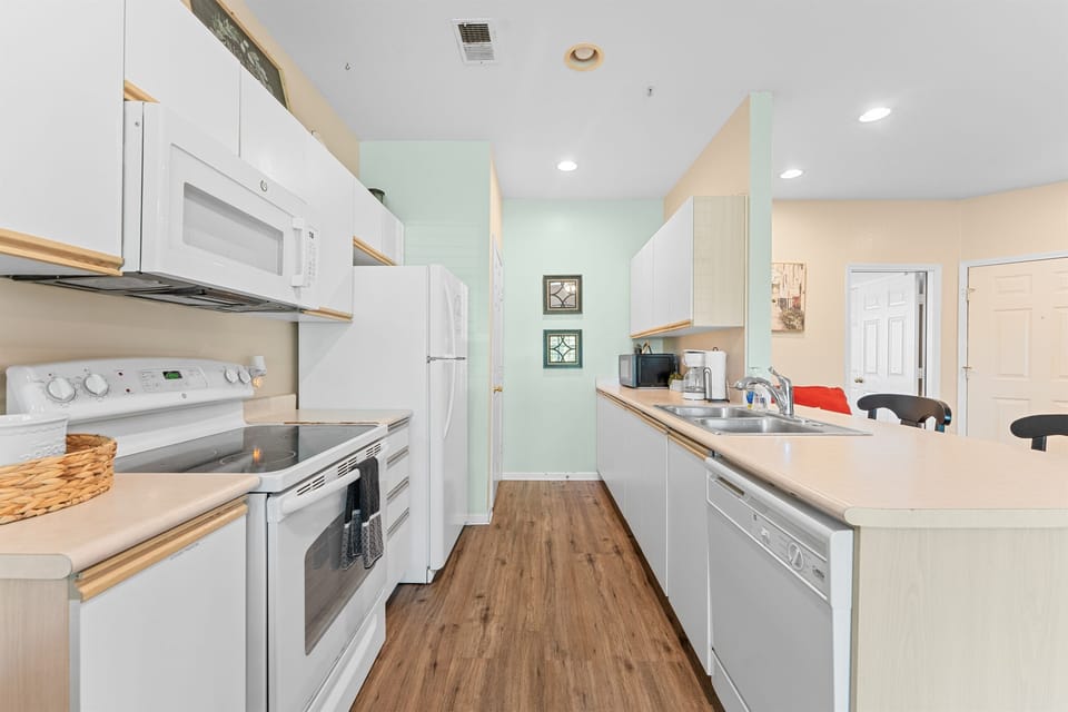 Bright galley kitchen with full-size appliances and generous prep space for easy breakfasts, snacks, and real meals.