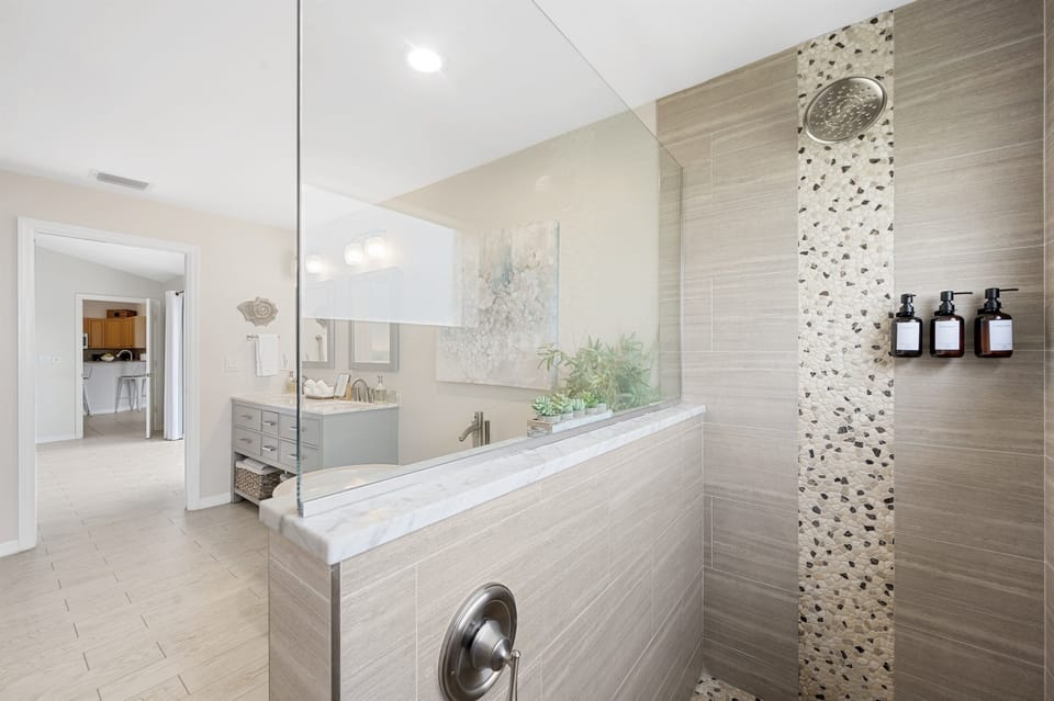 Step into a spacious walk-in shower with elegant tile and thoughtful touches