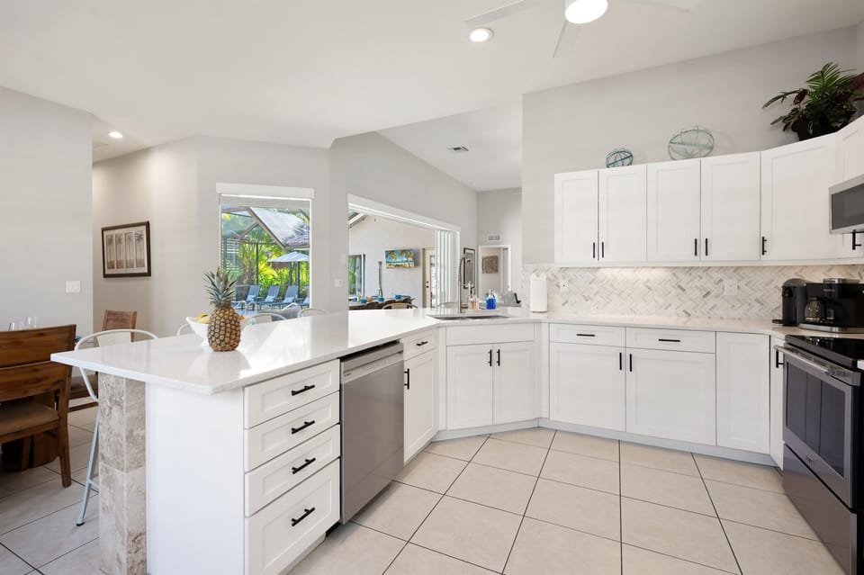 Bright, open-concept kitchen with modern finishes and seamless flow to the poolside patio