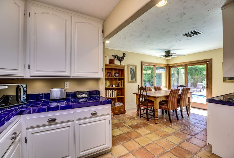 Dining off of kitchen with view of pool and rear garden. 