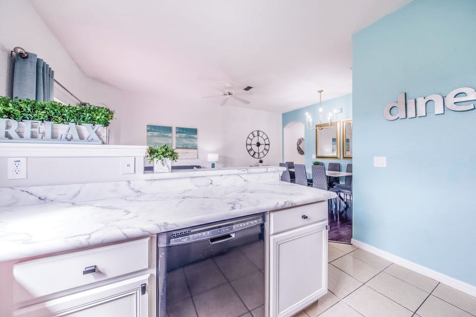 Open kitchen with stainless fridge, stove, microwave, dishwasher. 
