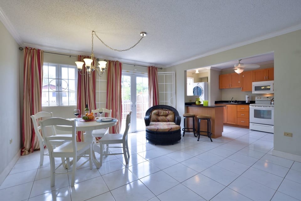 Panoramic View of Kitchen and Dining Room Shows French Doors that Leads to Backyard