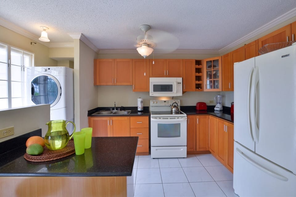 Kitchen View from Dining Room - Granite Countertops, Three Door Refrigerator, Electric Stovetop with 4 Burners, Microwave, Other appliance, and Front Load Energy-Efficient Washer and Dryer 