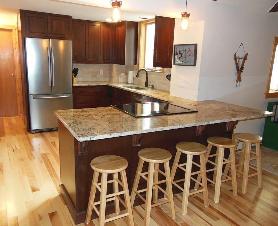 Open concept kitchen with granite counters, stainless appliances.