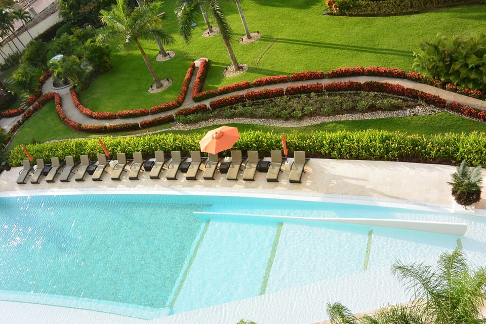 Lounge at relaxing pool with umbrellas and comfortable lounge chairs.