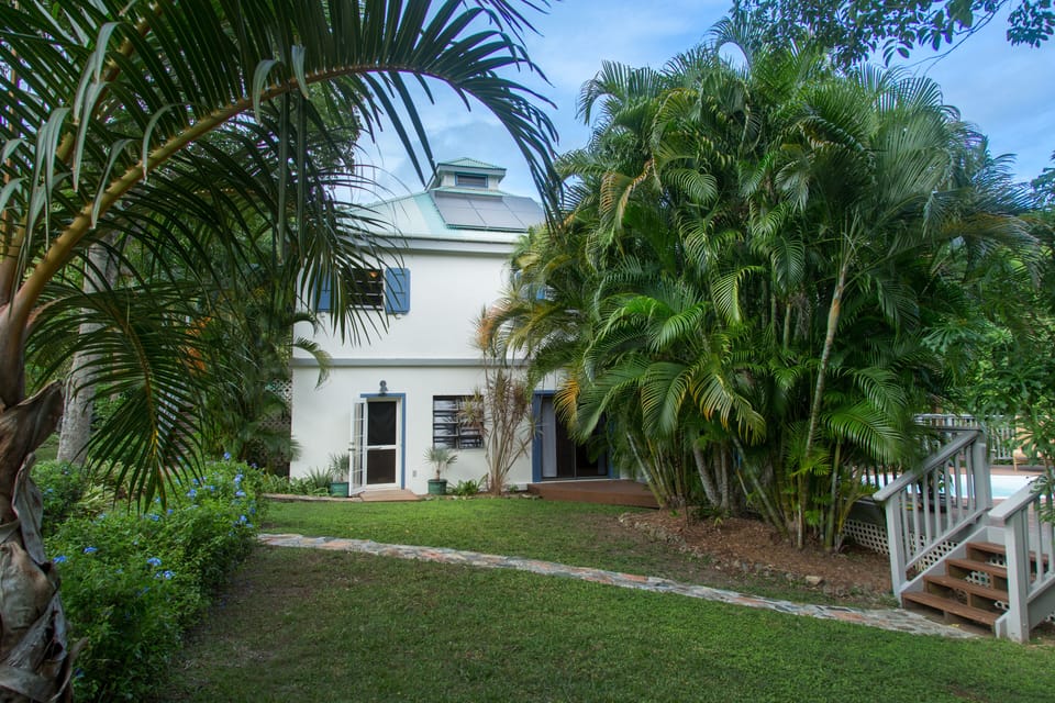 The flat front yard is great for kids and the Areca Palm hedge provides privacy