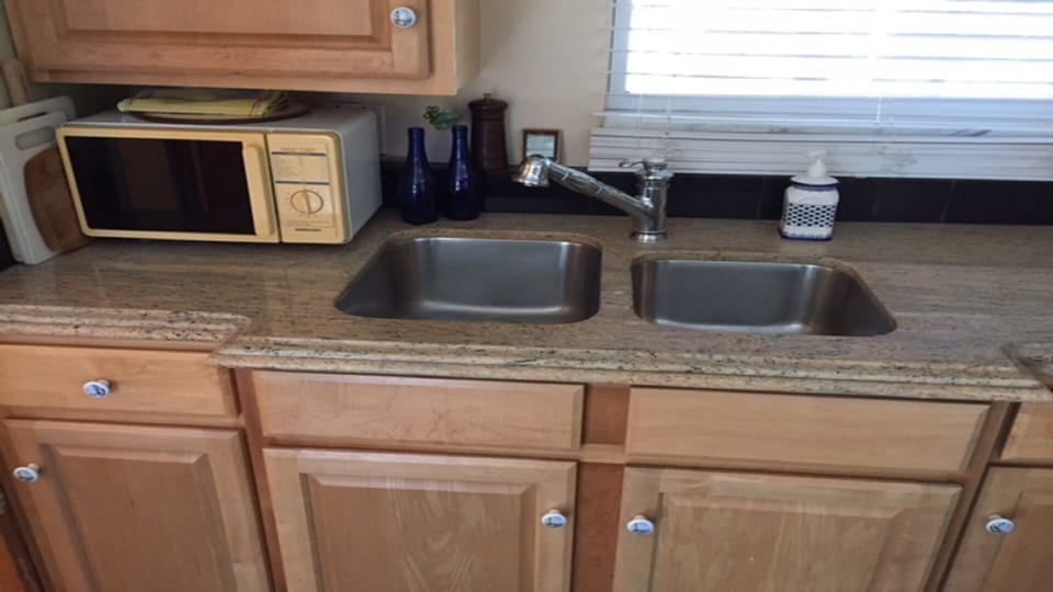 granite counter top with double sink and microwave