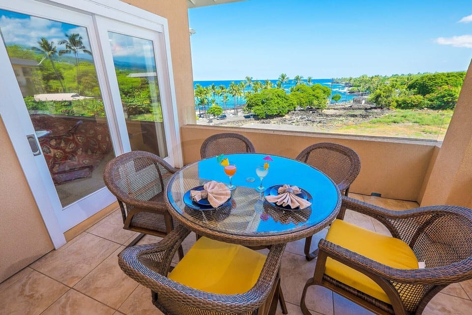 The outdoor lanai offers breathtaking views of Kahaluu Beach and the Kona coast.