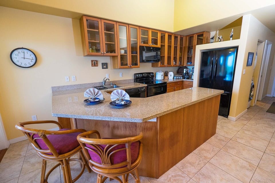 Kitchen features custom glass panel cherry wood cabinets and granite countertops