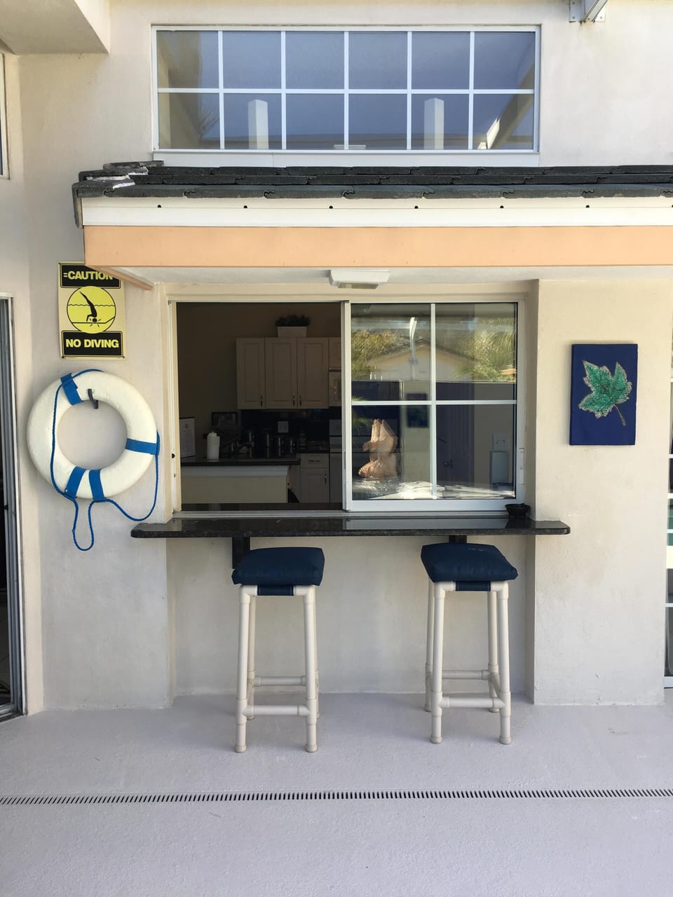 Outside bar area with sliding window leading to kitchen
