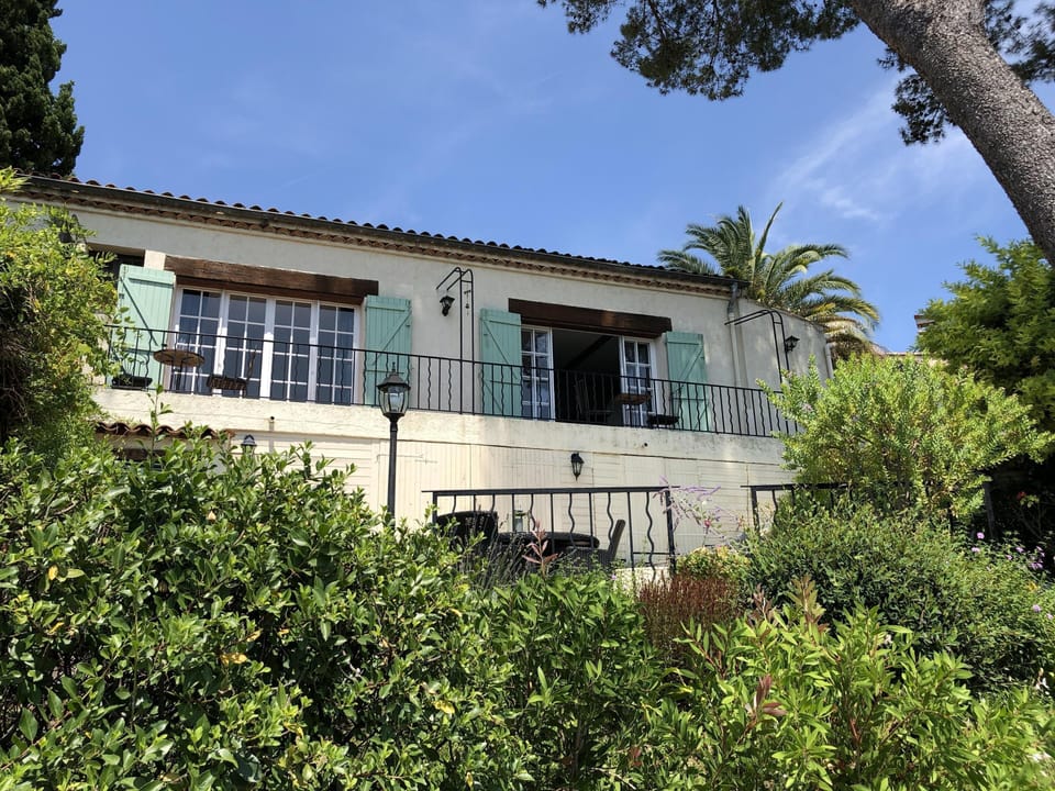 Villa's french doors and balcony with terraces below, and a private sunny garden