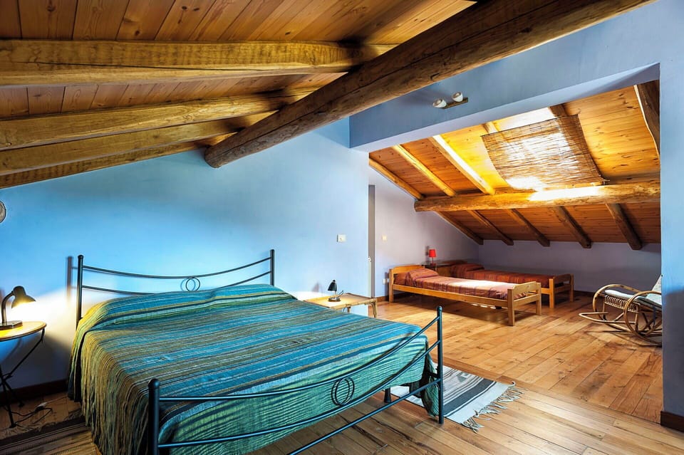 The large bedroom with large double bed and two single beds in the attic.
