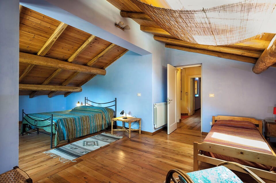 The large bedroom with large double bed and two single beds in the attic.