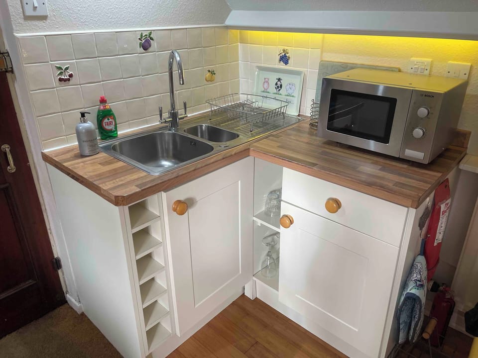 Fully equipped kitchen right side with microwave, blender, glasses