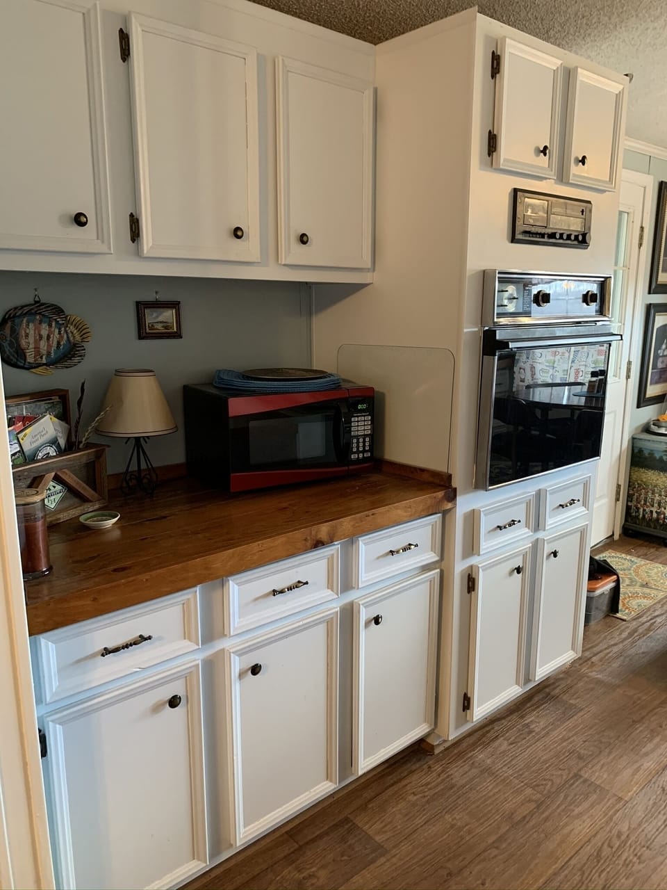 Microwave and oven, paper goods in cabinet for picnics.
