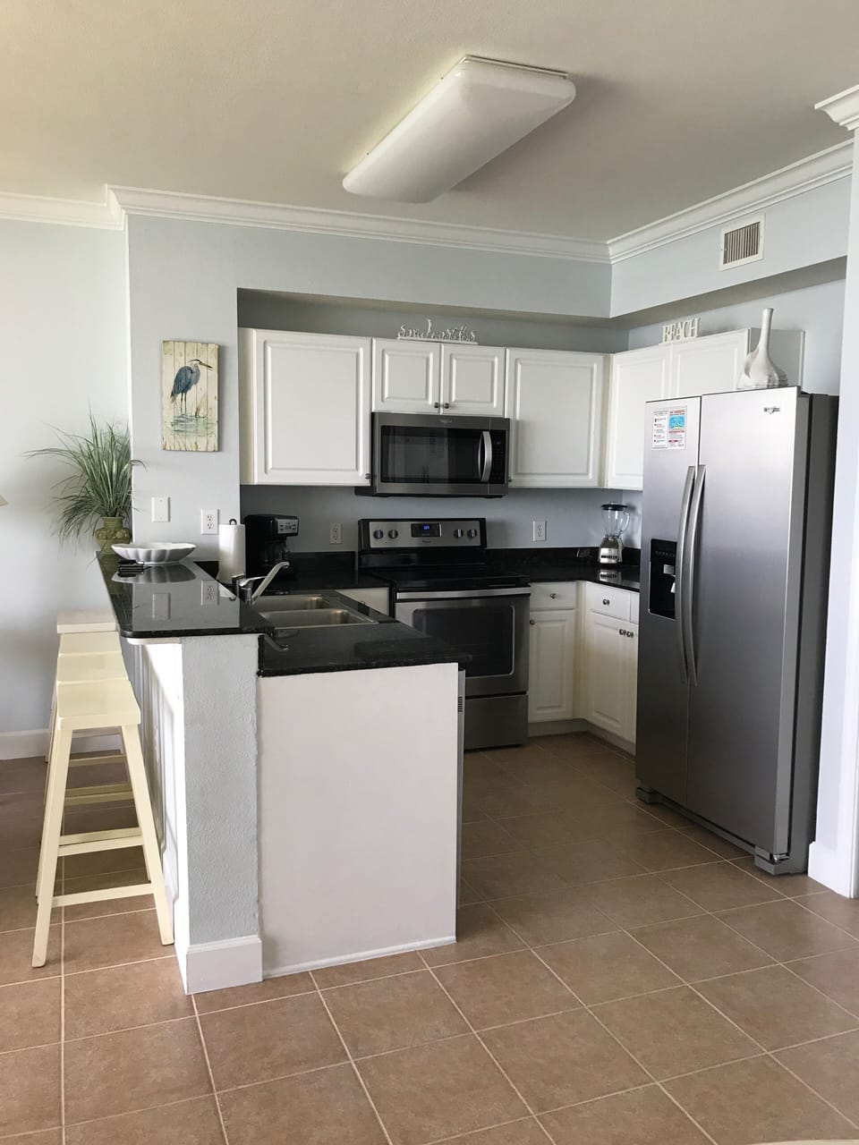 Spacious kitchen with 4 bar stools and all new stainless steel appliances