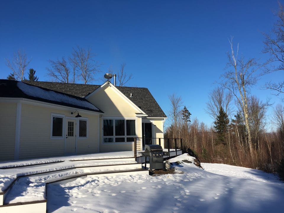 A different view of back of house and deck in winter
