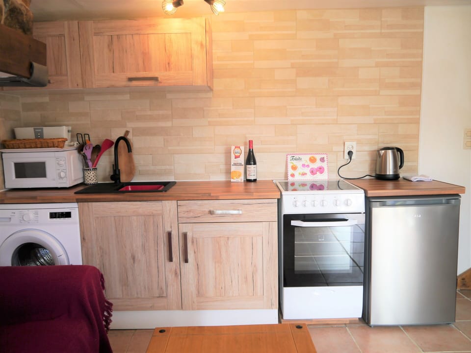 Kitchen area, with washing machine, microwave, electric cooker and fridge