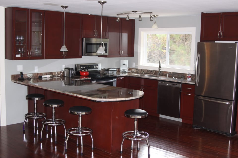 New kitchen with granite counter and seating for four.