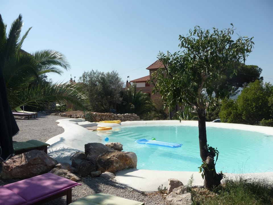 Natural lake-shaped pool in the middle of a Mediterranean garden 