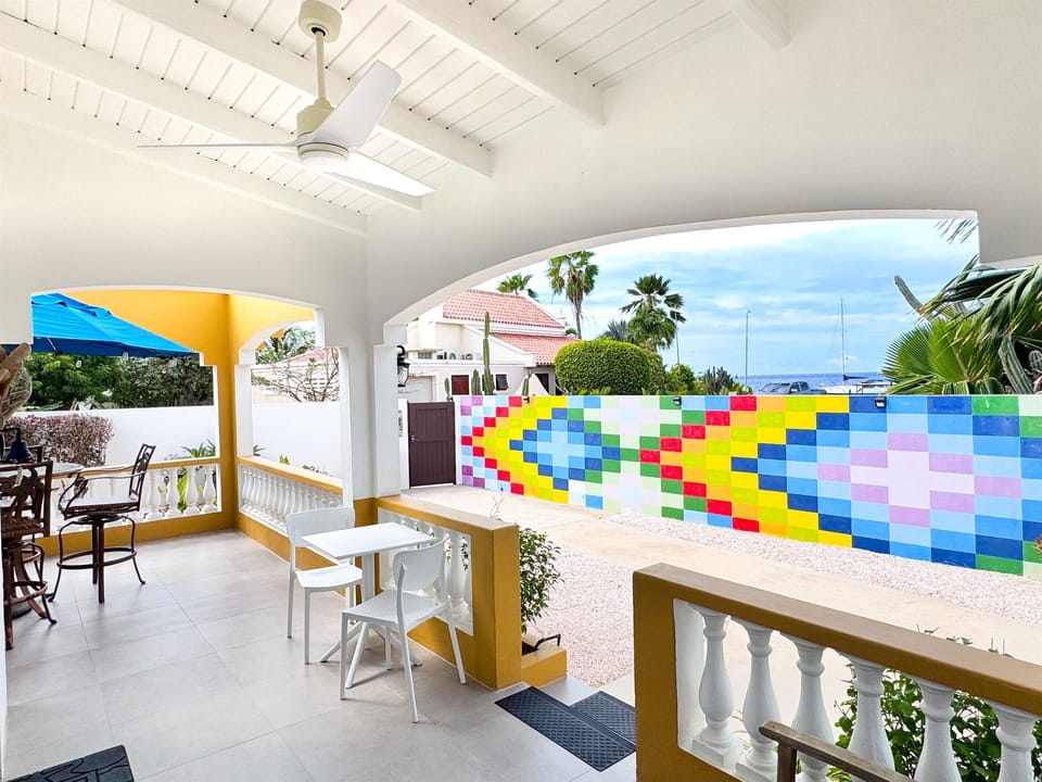 Kas di Amor’s front porch offers ocean views rising just above the colorful wall creating a calm ocean air place to unwind. 