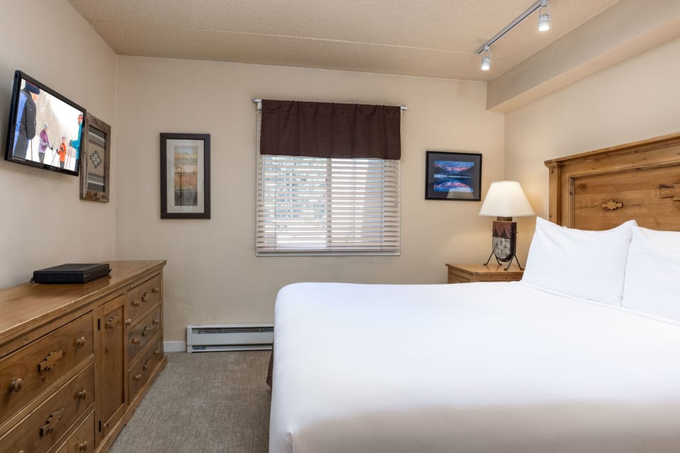 Slip into cloud-soft linens and unwind in your cozy bedroom, complete with warm wood furnishings and gentle natural light that promises restful nights.