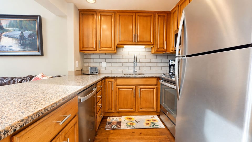 Your fully equipped kitchen features warm wood cabinetry, granite countertops, and stainless steel appliances—everything you need to whip up a meal or enjoy your morning coffee in comfort.