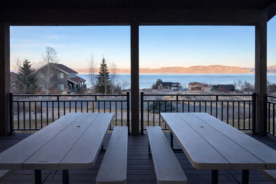 Spacious covered deck with seating for outdoor dining with a view.