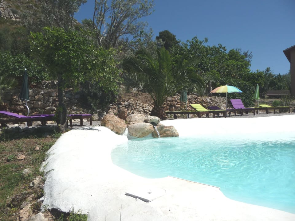 Natural lake-shaped pool in the middle of a Mediterranean garden with great view
