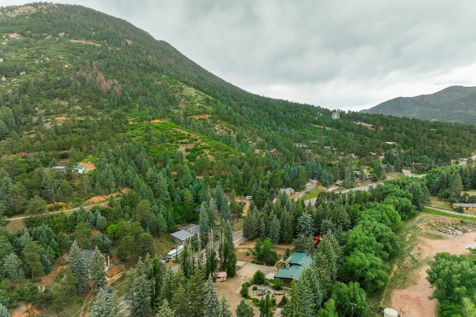 Aerial view of the property below towering mountains and the Pikes Peak highway