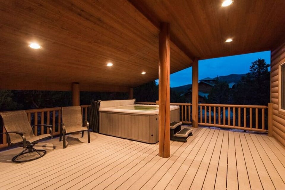 BACK PATIO FEATURES HOT TUB, BBQ, AND 4 TABLES FOR LARGE OUTDOOR GATHERINGS.
