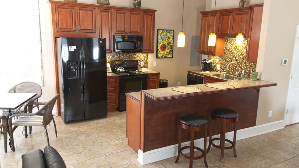 Kitchen with bar and dining area with 4 chairs.