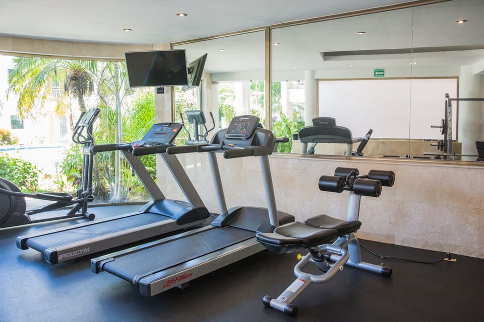 Gym with cardio and weights with pool view