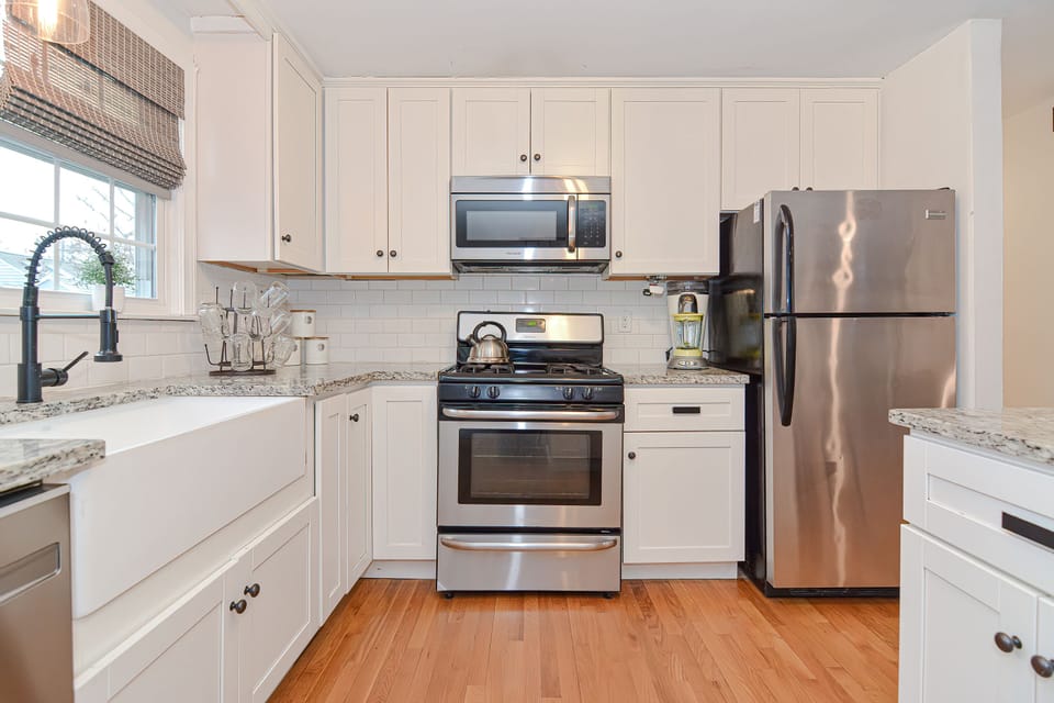 The Kitchen — Farmhouse sink, gas range, and granite counters, fully stocked.