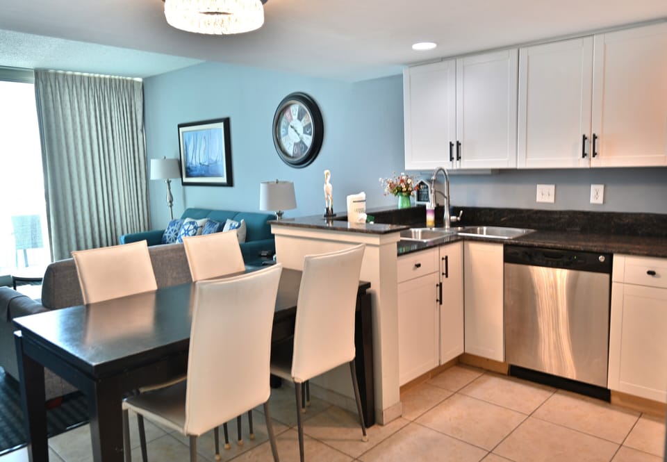 Modern kitchen and dining area with stainless steel appliances and cozy seating.
