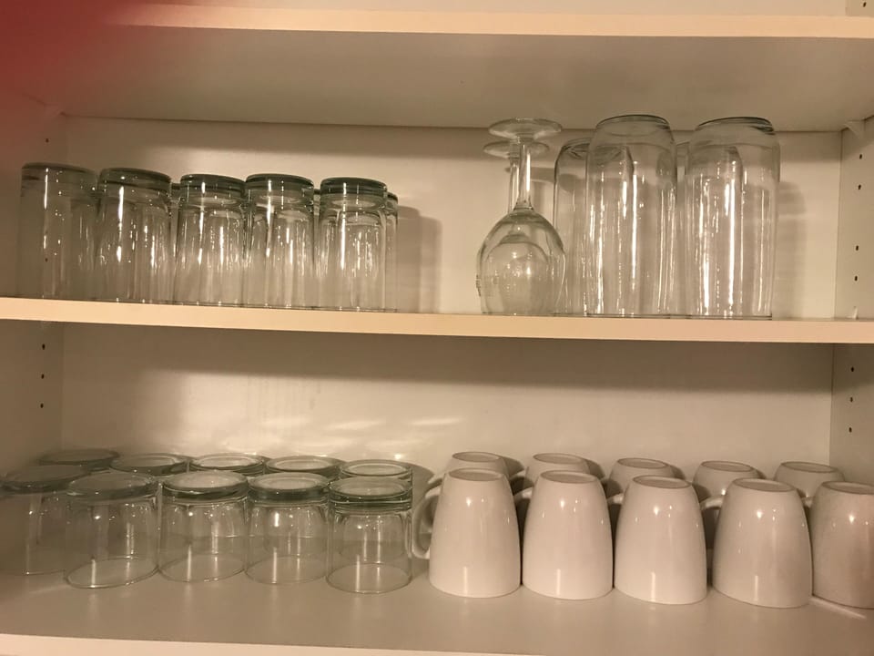 
Organized shelves with neatly arranged glasses and mugs.