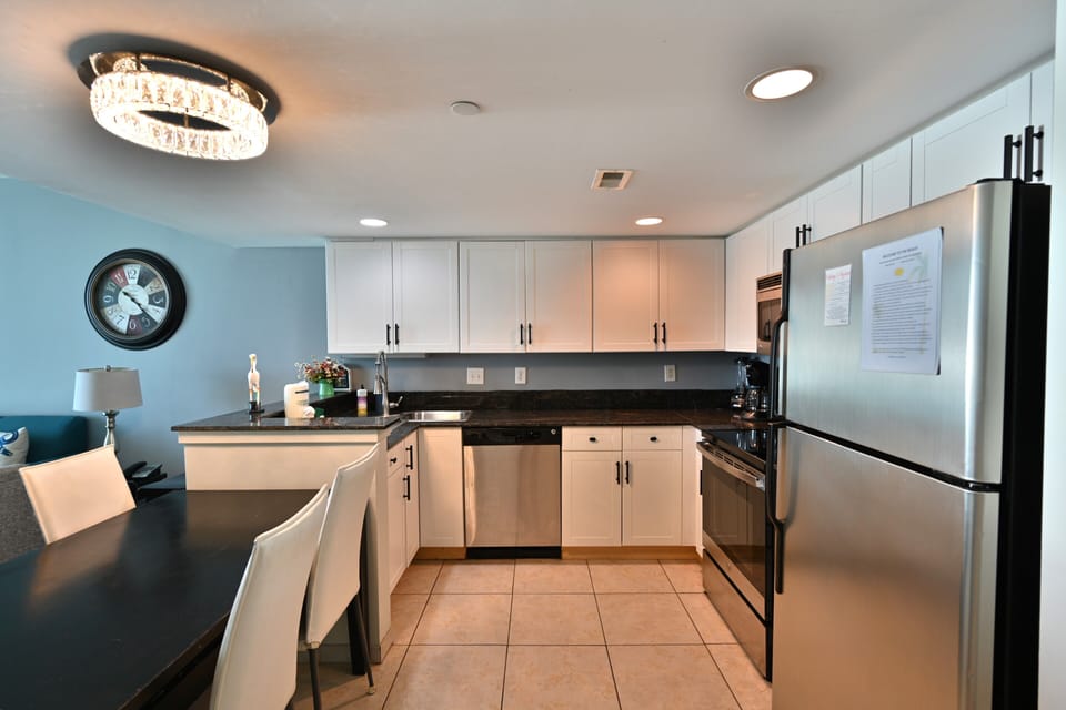 Stylish full kitchen with white cabinets and chandelier