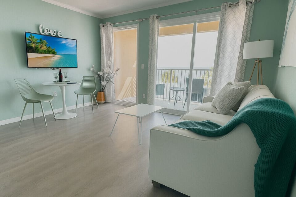 Living Room: Stylish space with bright decor and balcony views, perfect for relaxation or fun!