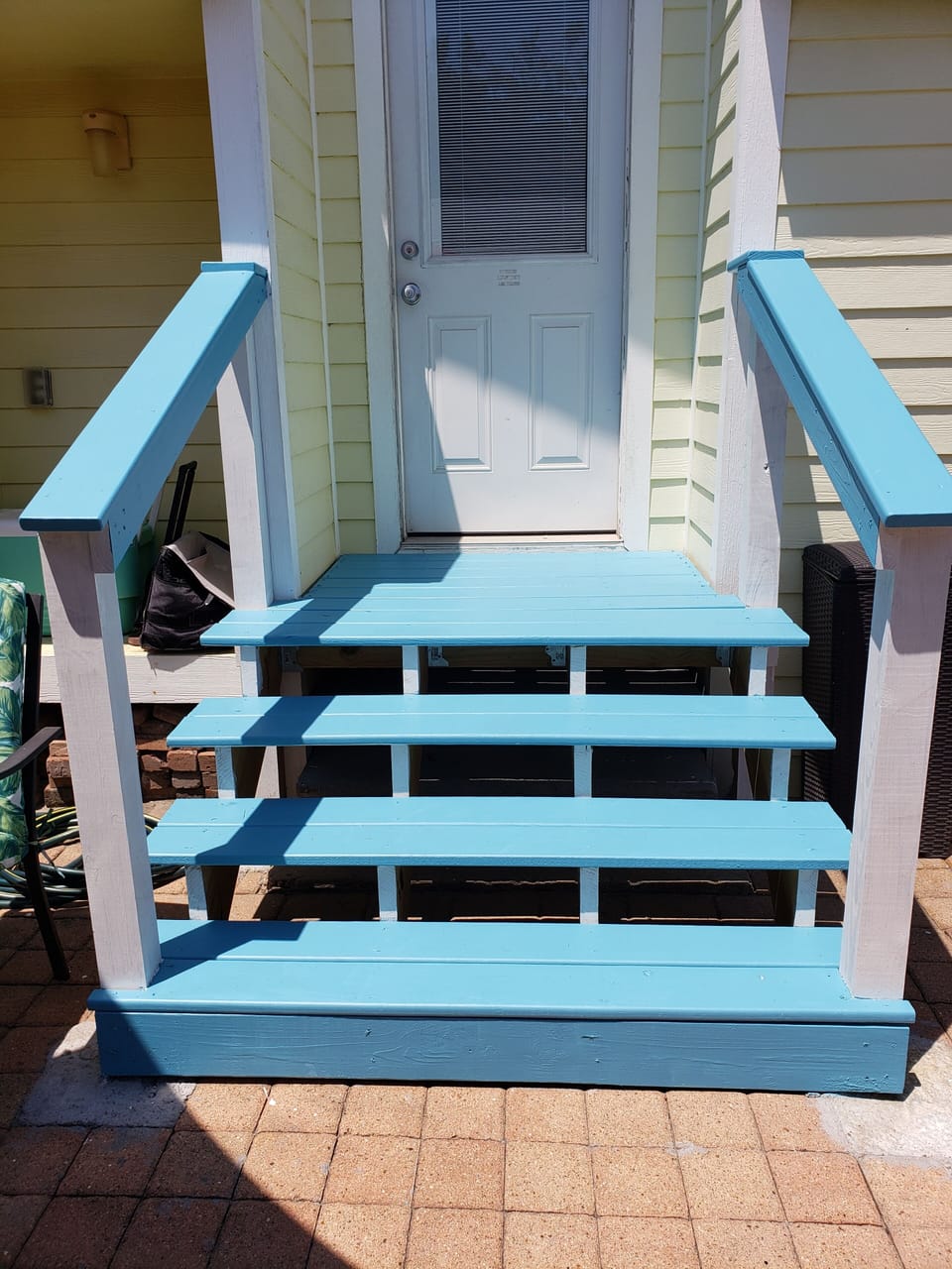 Deck and steps leading into the backyard with handrails for safety.