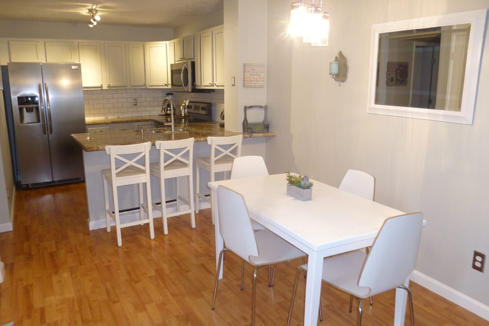 Dining room and kitchen with bar stools
