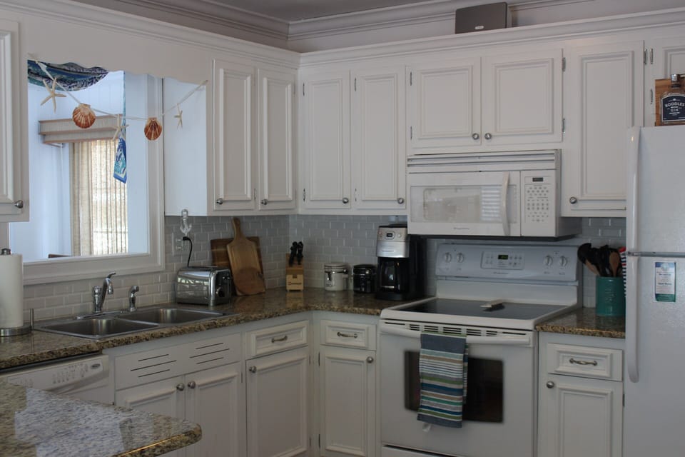 Fully stocked kitchen with dishwasher and electric oven.  