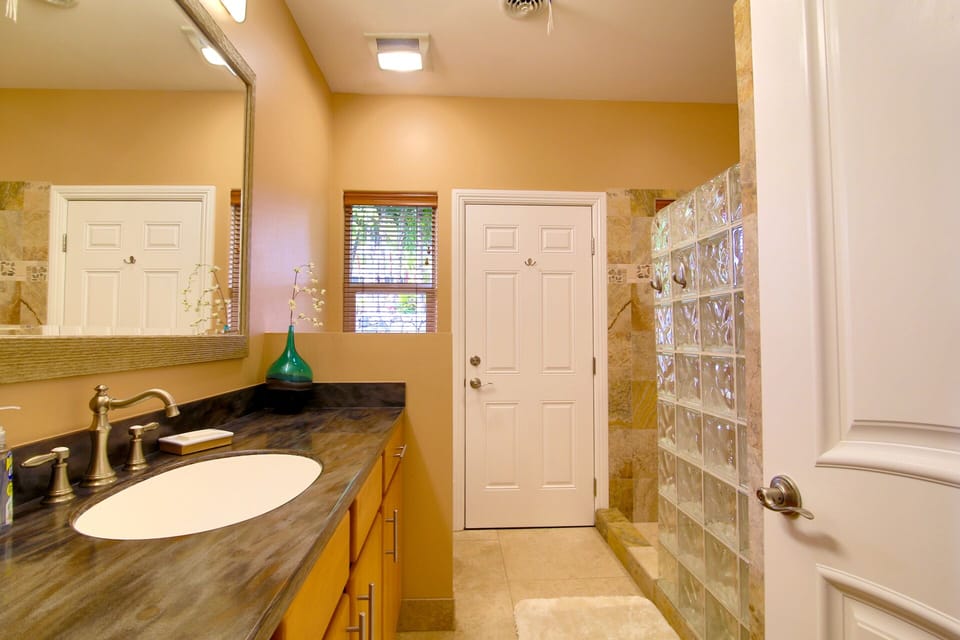 Bathroom with walk in shower and door leading to the pool 