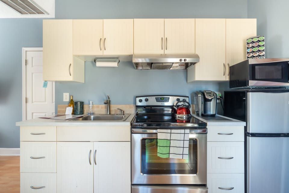 Full stove, microwave, coffee maker and refrigerator.