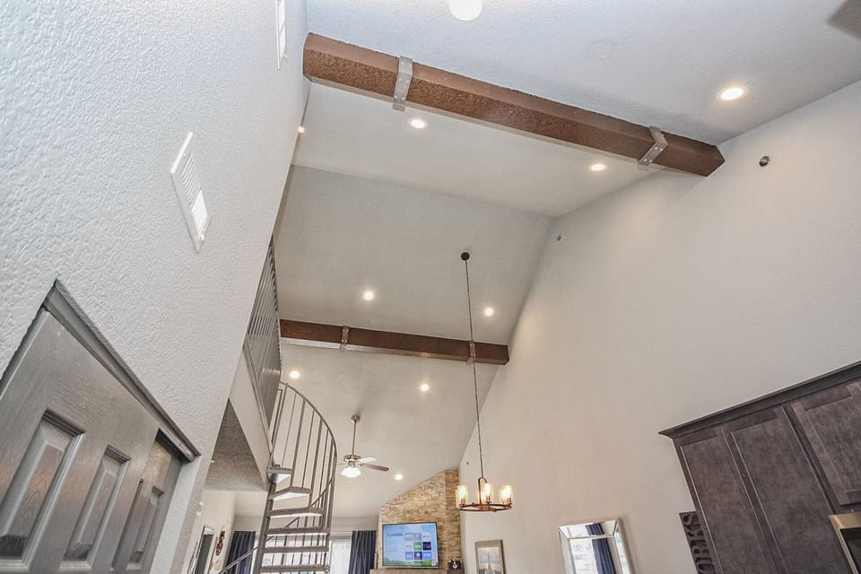 High vaulted ceilings w/ custom beams and tons of can lights.