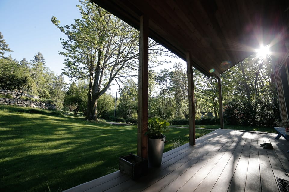 The expansive lawn with sun setting in the west off the edge of the front porch.