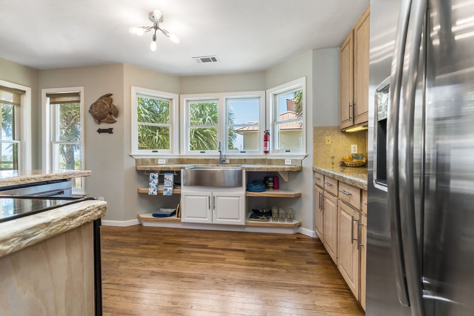 Stainless steel farmhouse sink and side by side fridge with filtered water/ice
