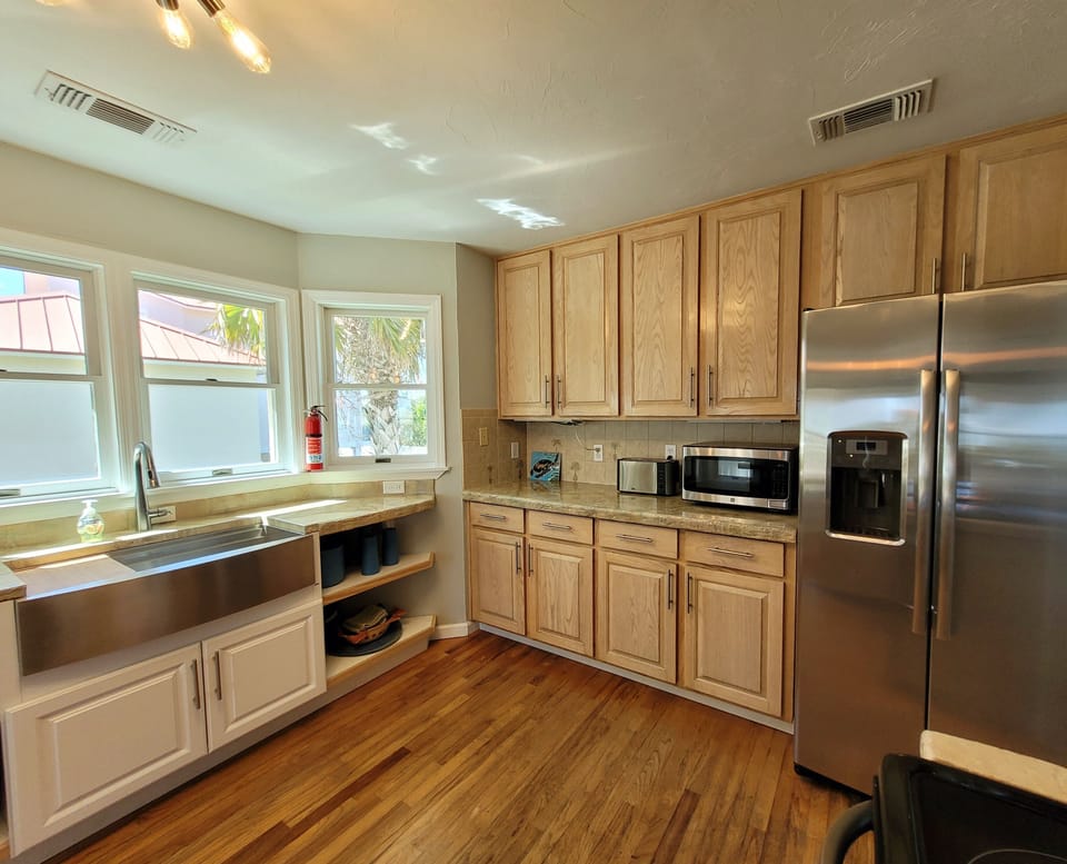 Kitchen with large stainless steel sink and fridge with filtered water and ice.