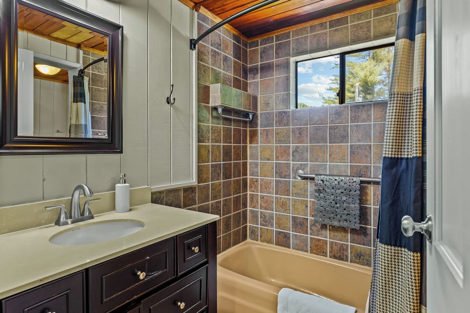 Master bathroom on main floor with vanity and tub/shower